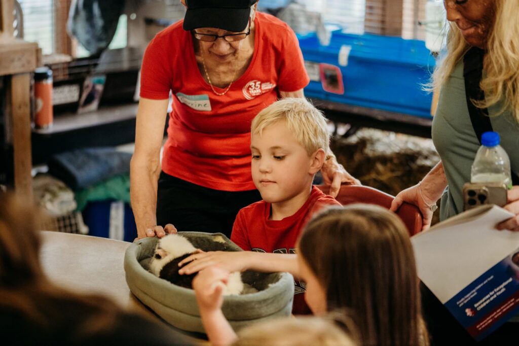 teacher or instructor guiding young students in a classroom like setting.